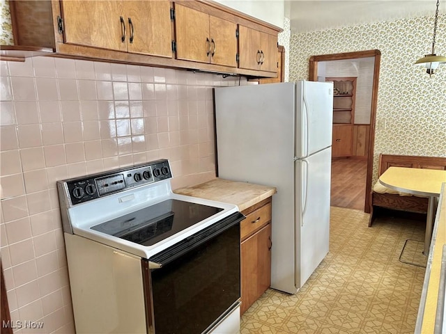 kitchen with tasteful backsplash, range with electric stovetop, and white fridge