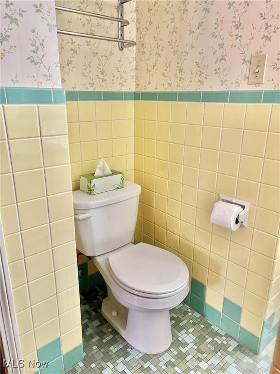 bathroom featuring tile walls, tile patterned floors, and toilet