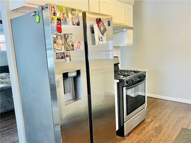 kitchen with stainless steel appliances, hardwood / wood-style floors, and white cabinets