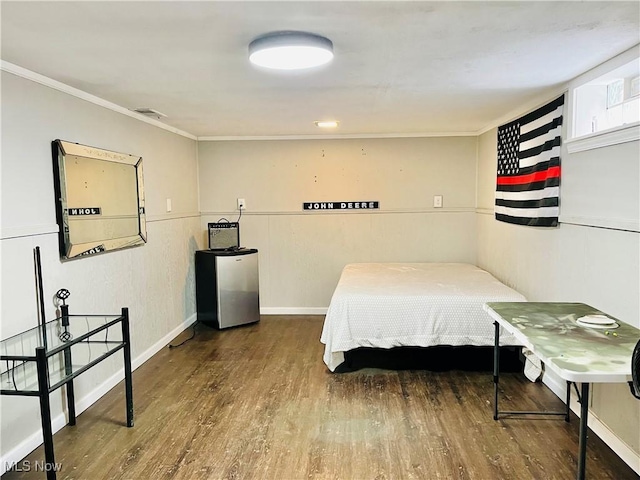 bedroom with hardwood / wood-style flooring, ornamental molding, and stainless steel refrigerator