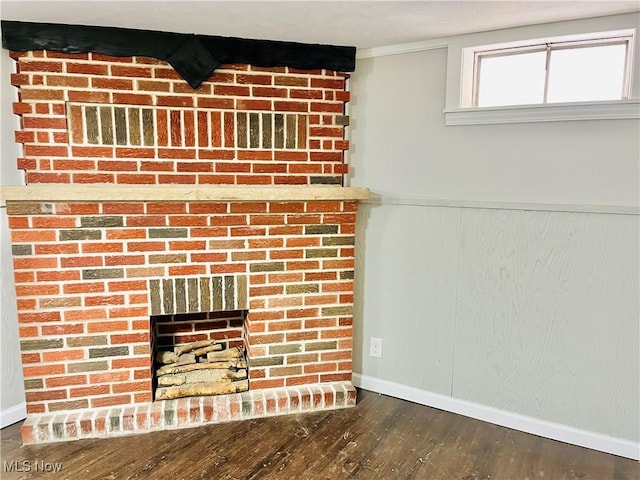 details featuring ornamental molding, hardwood / wood-style floors, and a brick fireplace