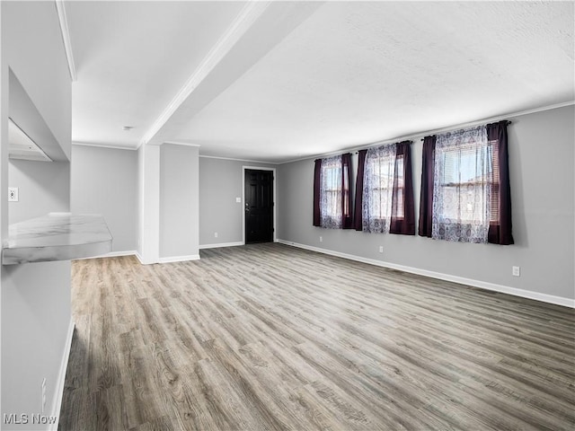 unfurnished living room with hardwood / wood-style floors and crown molding