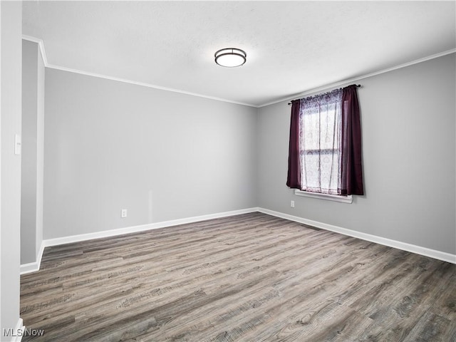 empty room featuring crown molding and hardwood / wood-style floors