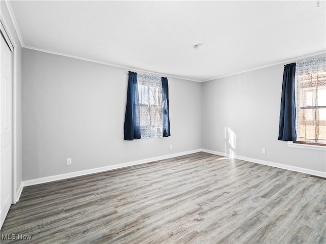 spare room with hardwood / wood-style flooring and crown molding