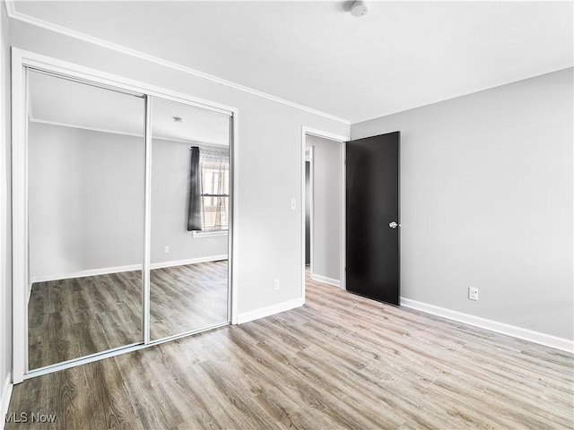 unfurnished bedroom featuring light hardwood / wood-style flooring and a closet