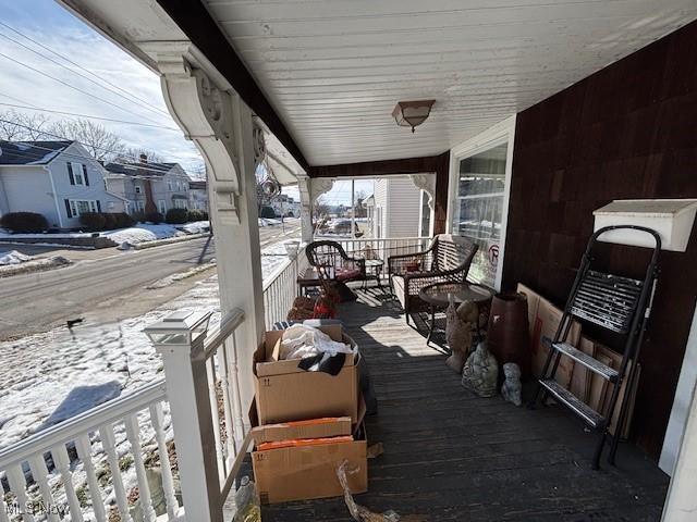 snow covered deck featuring a porch