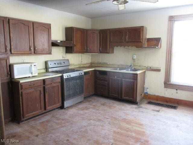 kitchen with sink, stainless steel stove, and ceiling fan