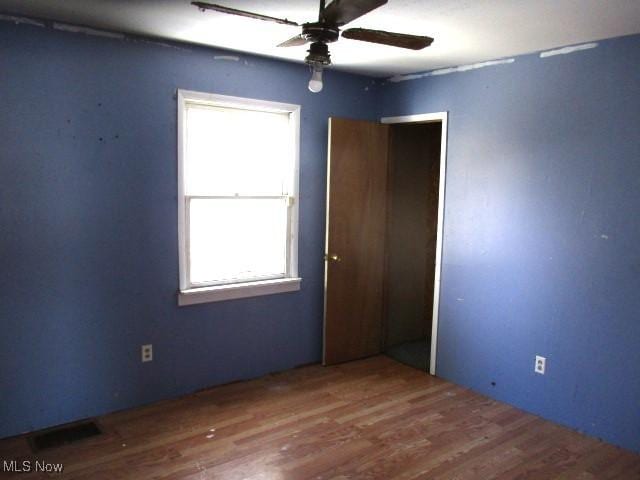 empty room with hardwood / wood-style floors and ceiling fan