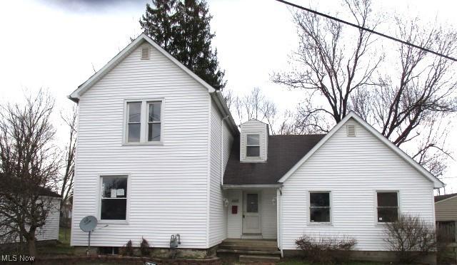 rear view of property featuring a chimney