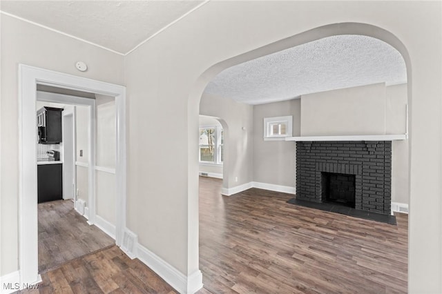 corridor with hardwood / wood-style floors and a textured ceiling