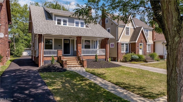 view of front of home with a porch and a front yard