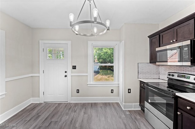 kitchen with dark brown cabinets, stainless steel appliances, and light wood-type flooring