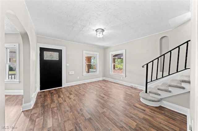 entrance foyer with dark wood-type flooring and a textured ceiling