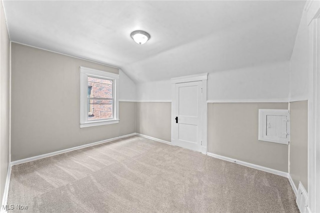 additional living space with vaulted ceiling and light colored carpet