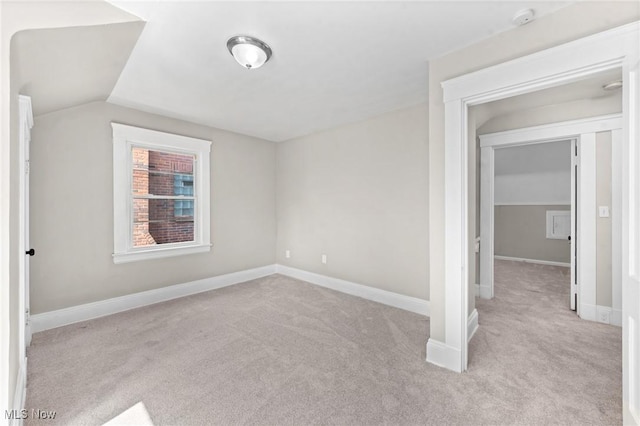 carpeted empty room featuring lofted ceiling