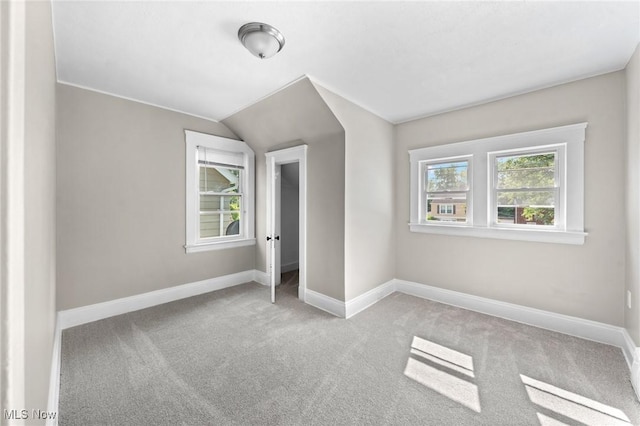 unfurnished bedroom featuring lofted ceiling and light carpet