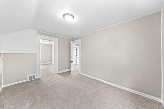 bonus room with vaulted ceiling and light carpet