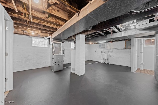 basement with sink, heating unit, and gas water heater