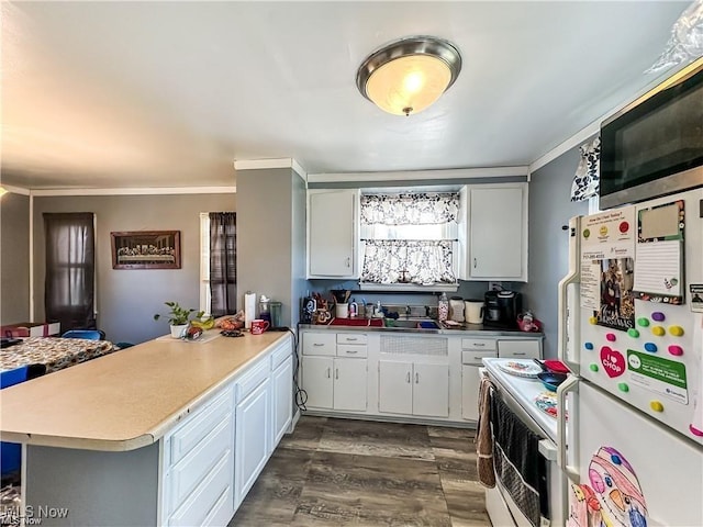 kitchen featuring white cabinetry, white appliances, dark wood-type flooring, and kitchen peninsula