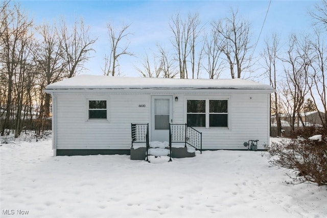 view of snow covered back of property