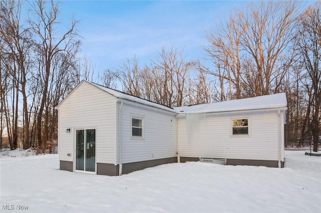 view of snow covered rear of property