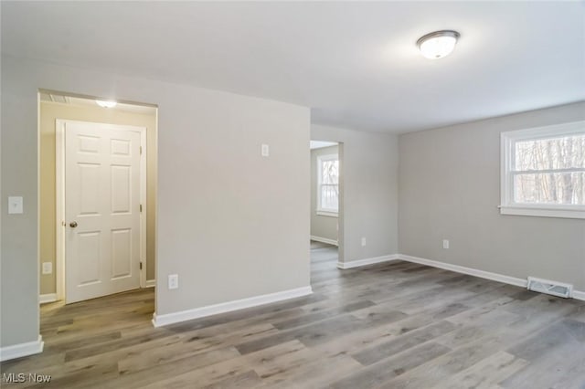 unfurnished room with hardwood / wood-style flooring