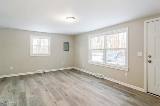 unfurnished room featuring electric panel and light wood-type flooring