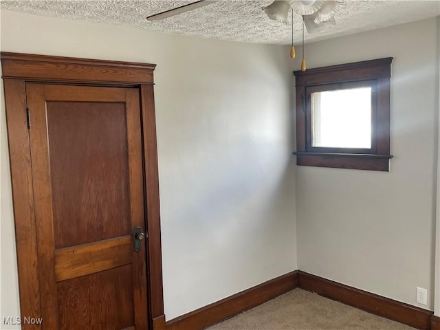 carpeted spare room featuring a textured ceiling