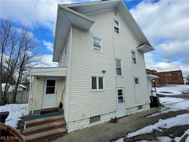 view of snow covered rear of property