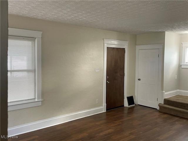 spare room with dark hardwood / wood-style flooring and a textured ceiling