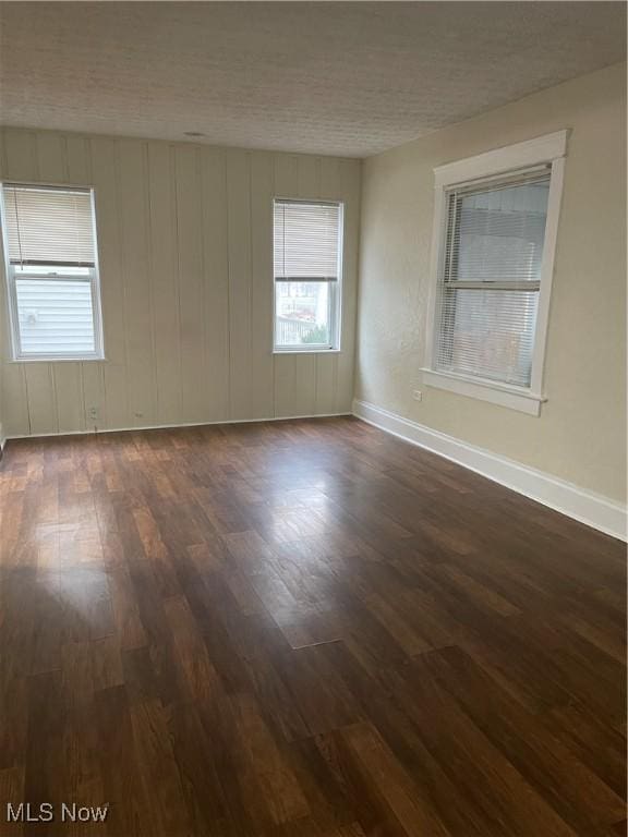 unfurnished room with dark hardwood / wood-style floors and a textured ceiling