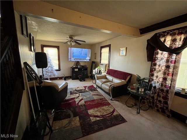 carpeted living room with beamed ceiling and ceiling fan