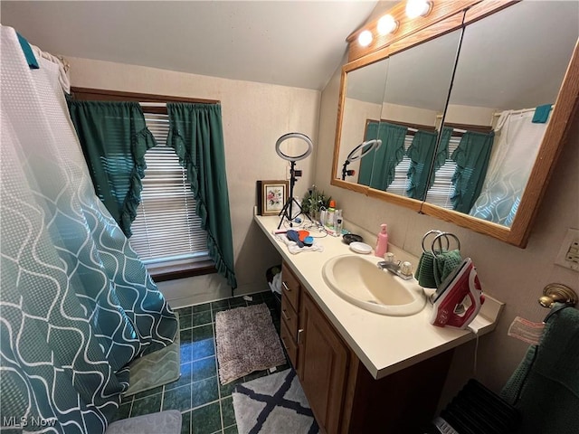 bathroom with vanity, lofted ceiling, and tile patterned floors