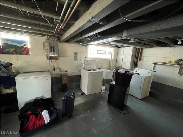 basement with refrigerator, electric panel, and washer and clothes dryer