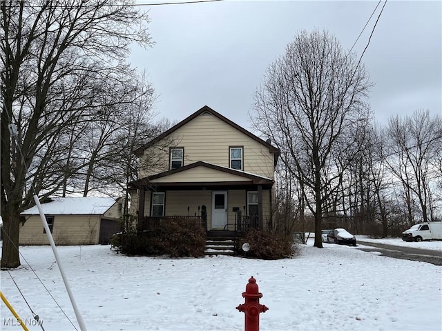 view of front facade featuring a porch, a garage, and an outdoor structure