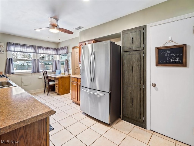 kitchen featuring sink, light tile patterned floors, stainless steel fridge, and ceiling fan