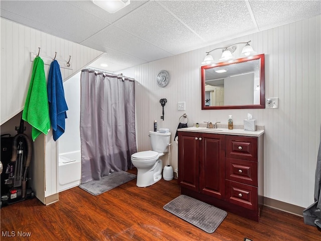 full bathroom with shower / tub combo with curtain, vanity, wood-type flooring, and toilet