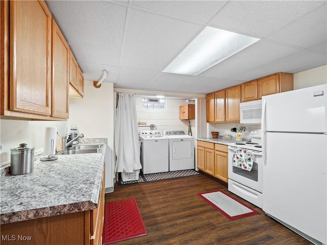 kitchen featuring washer and dryer, sink, dark wood-type flooring, a drop ceiling, and white appliances