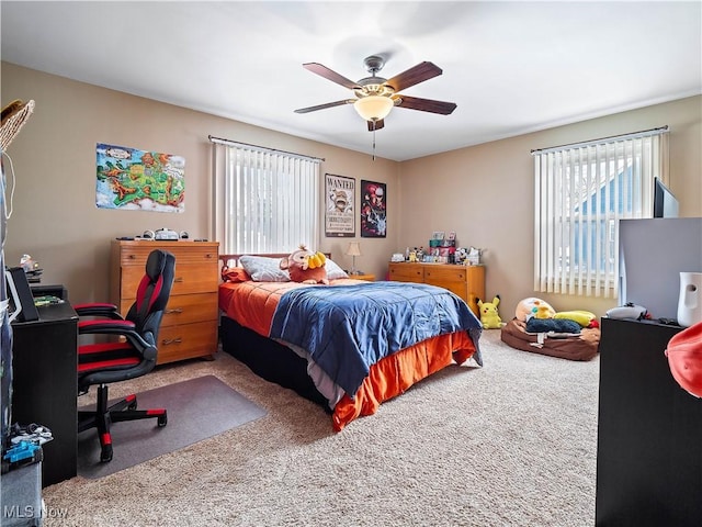 carpeted bedroom with multiple windows and ceiling fan