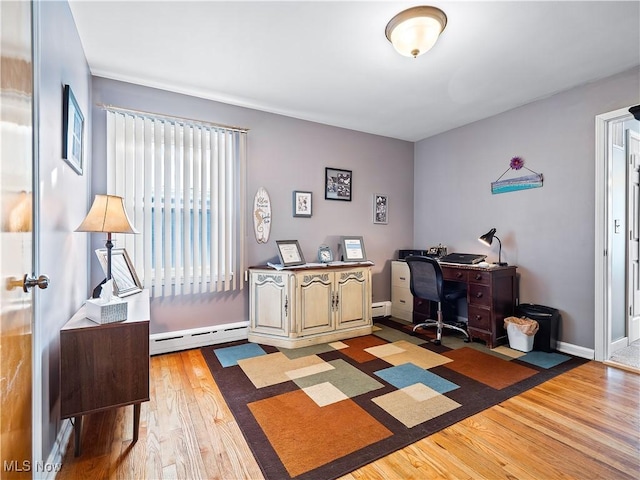 home office with a baseboard heating unit and light wood-type flooring