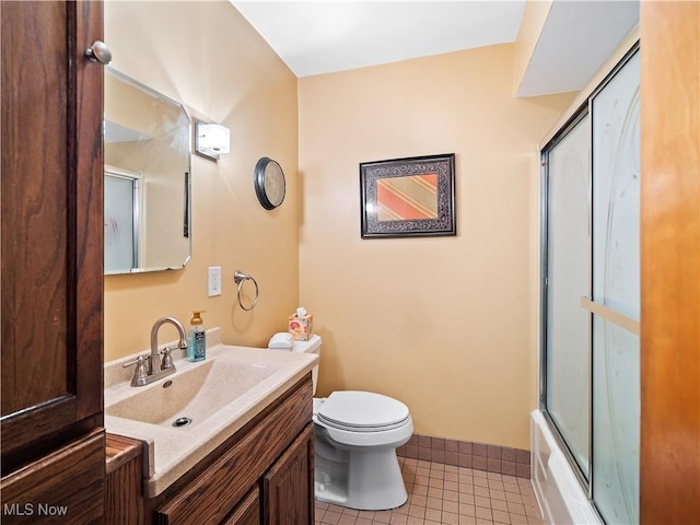 full bathroom featuring shower / bath combination with glass door, tile patterned floors, toilet, and vanity