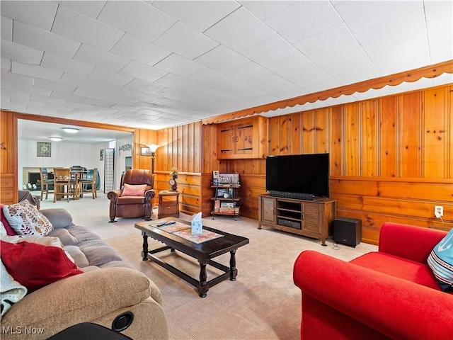 carpeted living room with wood walls