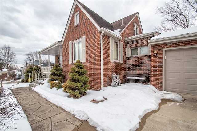 snow covered property with a garage