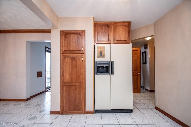 kitchen featuring light tile patterned flooring and white fridge with ice dispenser