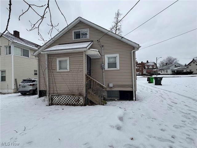 view of snow covered rear of property