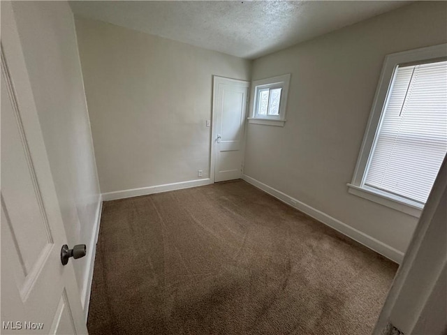 unfurnished room featuring carpet floors and a textured ceiling