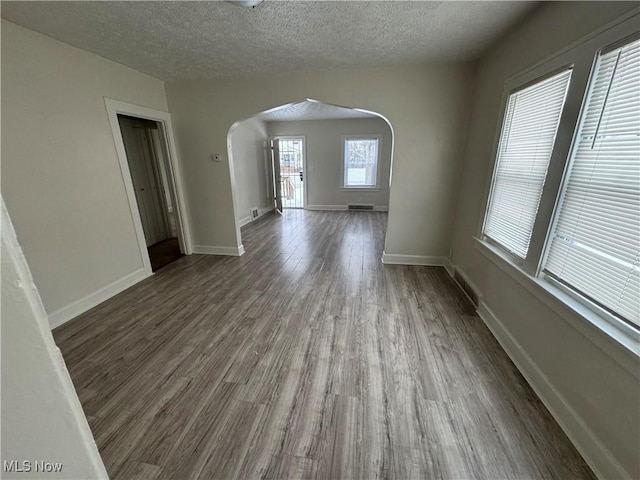 unfurnished room with hardwood / wood-style floors and a textured ceiling