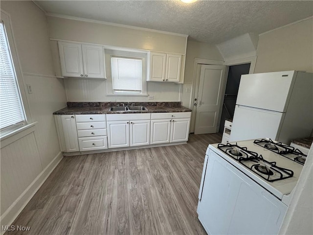 kitchen with sink, white appliances, light hardwood / wood-style floors, white cabinets, and a textured ceiling