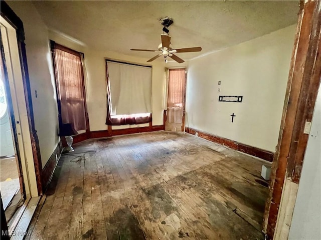 empty room with hardwood / wood-style flooring, plenty of natural light, and ceiling fan