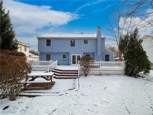 snow covered property with a deck